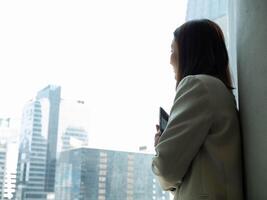 aussehen beim Fenster Geschäftsfrau weiblich Dame Mädchen Person Menschen Mensch Armkreuz Tablette Denken Idee Strategie Geschäft Kopieren Raum Treffen Technologie Arbeiten korporativ Büro Fachmann Manager Erfolg foto