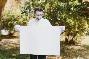Ihre Text Hier. Schauspieler Pantomimen halten leeren Weiß Brief. bunt Porträt mit Grün Hintergrund. April Dummköpfe Tag foto