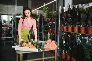 glücklich Mädchen Gärtner im das Blume Geschäft machen Blumensträuße zum ein Urlaub. Lebensstil Blume Geschäft. foto