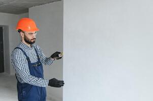 Hand Arbeiter halten Bürste Gemälde Weiß auf Holz Zaun foto