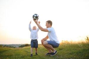 Vaters Tag. Papa und Sohn spielen zusammen draußen auf ein Sommer. glücklich Familie, Vater, Sohn beim Sonnenuntergang. foto