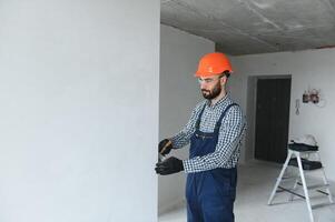 Hand Arbeiter halten Bürste Gemälde Weiß auf Holz Zaun foto