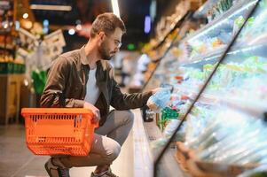 Mann Kauf Gemüse und Obst im wiederverwendbar Tasche im Lebensmittelgeschäft speichern, Null Abfall Konzept foto
