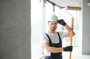 Maler Mann Gemälde das Wand, mit Farbe Rolle. foto