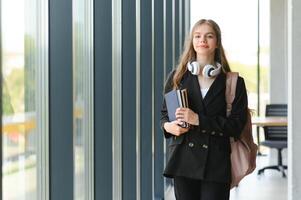 Schülerin Stehen mit Bücher und Rucksack beim Schule. foto