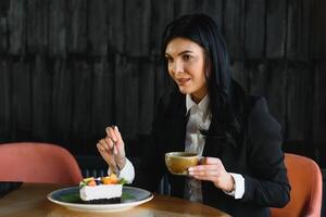 stilvoll Geschäft Frau Trinken Kaffee im Cafe mit Dessert beim Arbeit brechen foto