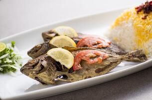 Mahi oder gebraten Fisch mit Reis serviert im Gericht isoliert auf grau Hintergrund oben Aussicht von Arabisch Essen foto