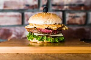 Grill nostalgisch Rindfleisch höchste Burger isoliert auf hölzern Tafel oben Aussicht auf Tabelle Fast Food foto