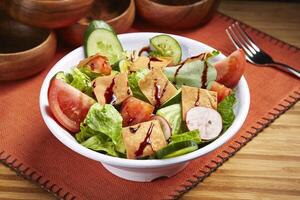 frisch fattoush Salat mit Tomate, Gurke und Grün Blatt serviert im Schüssel isoliert auf Tabelle Seite Aussicht von Mitte Osten Essen foto