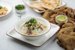 klassisch Hummus mit Kichererbsen serviert im Gericht isoliert auf Tabelle oben Aussicht von arabisch Essen foto