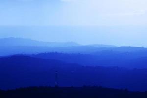 bergsommerlandschaft mit blauem farbverlauf von berggipfeln, naturreisen im freien hintergrund. foto