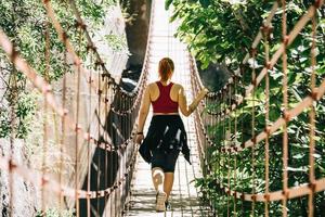 junge Frau auf einer Hängebrücke zu Fuß auf der Route Los Cahorros, Granada, Spanien?