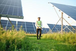 schließen oben Porträt von jung afrikanisch amerikanisch Ingenieur Arbeiter im Helm halten Solar- planen. Grün Elektrizität Zukunft Konzept. foto