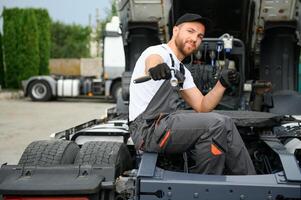 halb LKW unter Wartung. kaukasisch LKW Mechaniker Arbeiten zu Fix das Traktor. foto