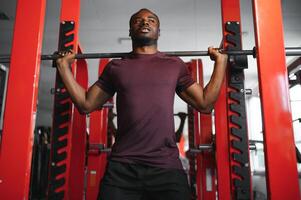 gut aussehend jung afrikanisch amerikanisch Mann Arbeiten aus beim das Fitnessstudio foto