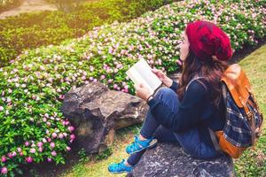 Frau reisen Natur im Blumengarten. Entspannen Sie auf Felsen sitzen und Bücher lesen inmitten der Natur im Nationalpark Doi Inthanon.
