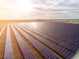 Antenne oben Aussicht von ein Solar- Paneele Leistung Pflanze. Photovoltaik Solar- Paneele beim Sonnenaufgang und Sonnenuntergang im Landschaft von über. modern Technologie, Klima Pflege, Erde sparen, verlängerbar Energie Konzept. foto