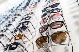 Reihe von Brille beim ein Optiker. Brille Geschäft. Stand mit Brille im das Geschäft von Optik. roh von Mode Eleganz Sonnenbrille im das speichern. foto