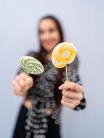 Mode Modell- Mädchen mit runden Süßigkeiten im Hände. schön lächelnd jung Frau. abgeschnitten Foto. foto