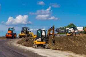 Panorama von Arbeiten Maschinen beim Straße. Gebäude Neu Straße. anders Typen von Arbeiten Straße Ausrüstung. foto