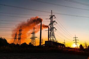 dunkel Schatten von hoch Stromspannung elektrisch Türme. Sonnenuntergang Silhouetten von groß elektrisch Konstruktion. foto