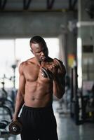 afrikanisch Sport Mann mit Hantel Übung beim Fitnessstudio. asiatisch Körper Gebäude zum Muskel Ausbildung. Sport Gesundheit Fitnessstudio Konzept foto