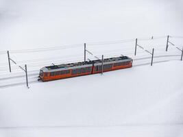 hell Orange Zug im schneebedeckt Landschaft, zermatt Ski Resort Bereich Antenne Aussicht foto