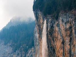 majestätisch Wasserfall, und neblig immergrüne Pflanzen, schließen zu murren im Schweiz. foto