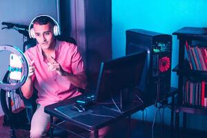 jung latinx Spieler Mann mit Headsets Streaming Leben Video. foto