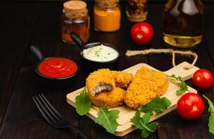 köstlich frisch knusprig Hähnchen Nuggets auf ein dunkel hölzern Hintergrund. ungesund Essen, schnell Essen foto