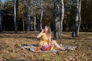 schöne Frau im gelben Kleid bei einem Picknick foto