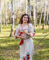schöne Frau in ukrainischer Tracht, die im Wald tanzt foto