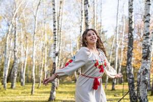 schöne Frau in ukrainischer Tracht, die im Wald tanzt foto