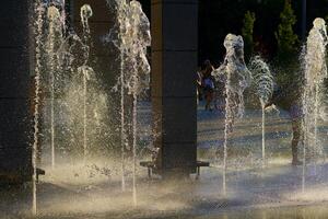 cool Wasser Brunnen fließen im das Sommer- Hitze foto