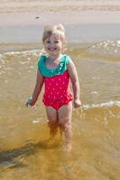 jung glücklich Kind Mädchen von europäisch Aussehen Alter von 4 haben Spaß im Wasser auf das Strand ,tropisch Sommer- Berufe,Ferien.a Kind genießt das Meer.vertikal Foto. foto