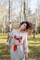 schöne Frau in ukrainischer Tracht, die im Wald tanzt foto