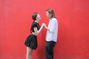 ein Paar ist genießen ein Sommer- Ferien im das rot Mauer Hintergrund, glücklich zeigen ihr Liebe zu jeder andere. foto