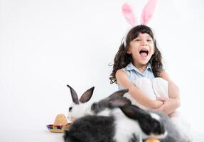 lächelnd wenig Mädchen und mit ihr Geliebte flauschige Kaninchen, präsentieren das Schönheit von Freundschaft zwischen Menschen und Tiere foto