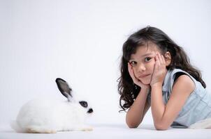 lächelnd wenig Mädchen und mit ihr Geliebte Kaninchen, präsentieren das Schönheit von Freundschaft zwischen Menschen und Tiere foto