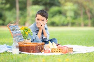 glücklich Familie genießen ein Picknick im das Park, mit Kinder haben Spaß Sitzung, umgeben durch Natur foto