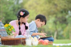 glücklich Familie genießen ein Picknick im das Park, Kinder Sitzung zurück zu zurück und lesen Bücher. foto