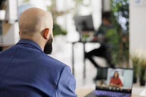 Exekutive Manager diskutieren Start oben Projekt mit Investor auf Laptop im Geschäft Büro. Unternehmer Hören zu Frau Geschäft Partner präsentieren Idee im Video Konferenz foto