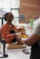 afrikanisch amerikanisch Frauen präsentieren vor kurzem gepflückt Zitronen beim das Kassierer Schreibtisch. Bild präsentieren ein weiblich Kunde Angebot Früchte zu ein schwarz Verkäufer zu wiegen. foto