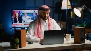 arabisch Geschäftsmann beginnend seine Tag Arbeiten von heim, Öffnung Laptop, Surfen das Netz. Mitte östlichen Mann ankommen im persönlich Wohnung Büro mit Tasse von Kaffee, bereit zu lösen Aufgaben foto