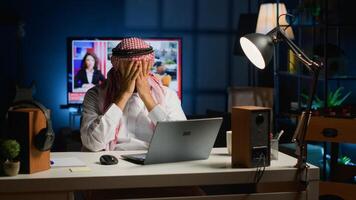 arabisch Geschäftsmann Leiden Migräne Arbeiten von Zuhause während mit Laptop selbst beschäftigt Mitte östlichen Mann im persönlich Wohnung Büro antworten E-Mails bekommen Kopfschmerzen von Überarbeitung foto