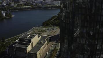 oben Aussicht von Glas Fassade von Hochhaus Gebäude mit Landschaft von Stadt und Fluss. Lager Filmaufnahme. schön Landschaft von modern Stadt mit Glas Gebäude. Glas Wolkenkratzer mit Grün Landschaften von foto