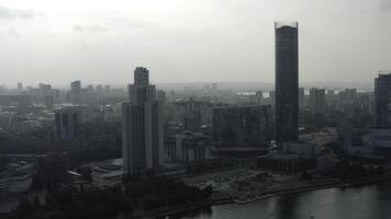 oben Aussicht von modern grau Stadt im wolkig Wetter. Lager Filmaufnahme. grau wolkig Stadt mit Fluss und Nebel. wolkig Tag hängend Über modern Stadt foto