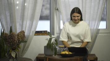 jung Frau Getränke Tee und sieht aus beim Tablette im Cafe. Medien. Schüler Uhren Video auf brechen und Getränke Tee im gemütlich Cafe. jung Frau ist entspannend Aufpassen Tablette und haben Tee im Cafe foto