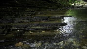 klar Strom Laufen durch Stein Felsbrocken. kreativ. Ruhe Fluss fließend auf Stein Unterseite im schleppend Bewegung. foto