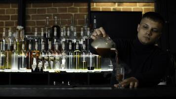 schließen oben von Barmann beim ein Bar Zähler Gießen Alkohol in Jahrgang Glas. Medien. Gießen rot heiß alkoholisch Tinktur mit Dampf. foto